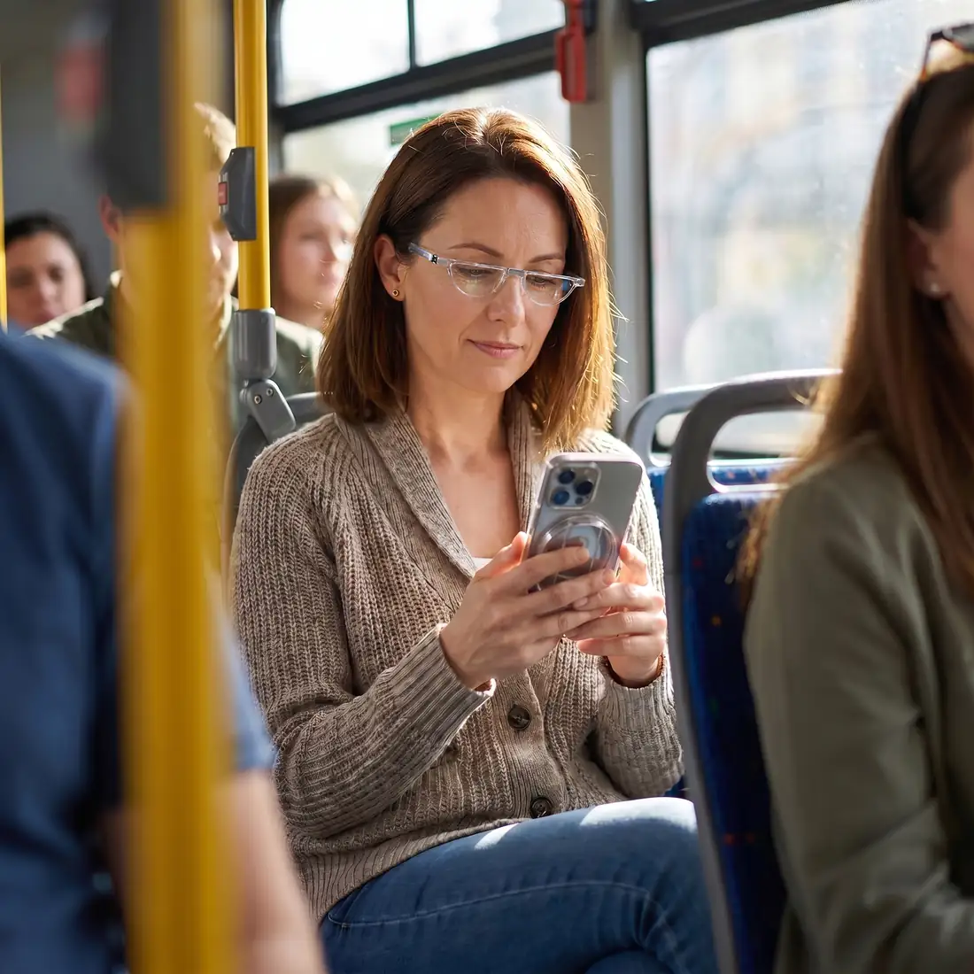 Woman on a bus reading her phone wearing minrims